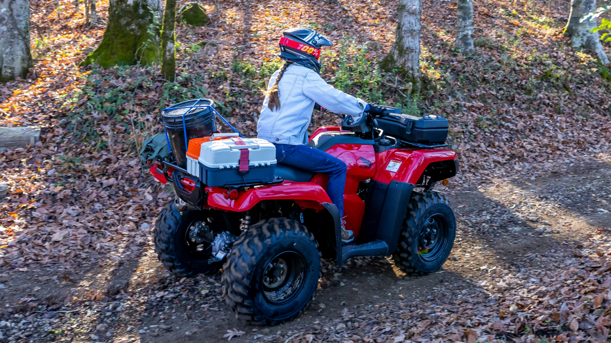 Driver on rancher going right on road covered in leaves.