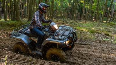 Rider on Rubicon going right on dirt track in woods.