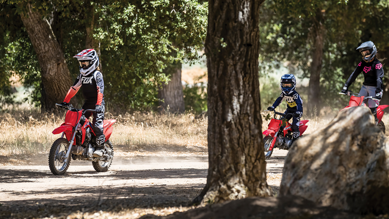 Three riders parked on Honda Trail bikes