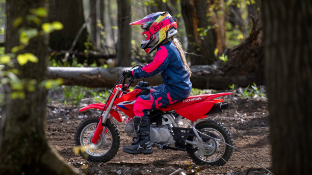 A young rider on a CRF50F on a trail
