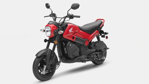 A 3/4 view of a Honda Navi and rider showing its seat and foot pegs