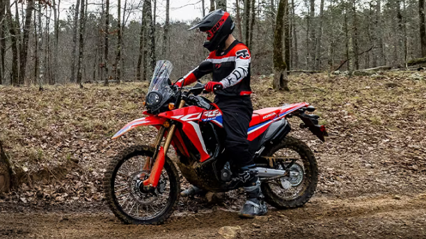 A side angle view of a person riding the Honda CRF300L