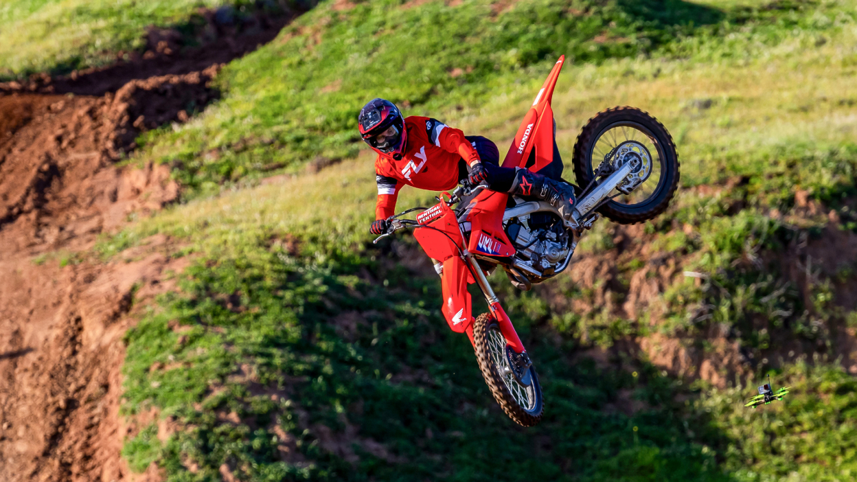 Un motard en plein vol. Champ vert en arrière-plan.