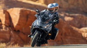 Head on view of rider and passenger on NT1100. Red Rocky landscape in background.