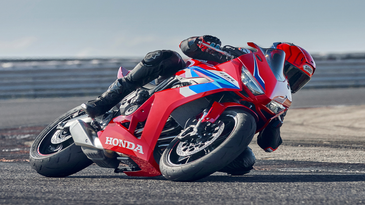 Rider on CBR1000RR-R Fireblade making sharp left turn on race track.