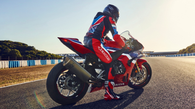 Rear view of rider stationary on CBR1000RR-R Fireblade on race track.