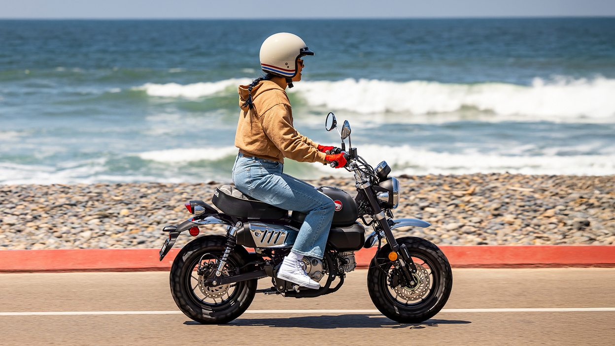 Un motard roule à droite sur la route. Plage en arrière-plan.