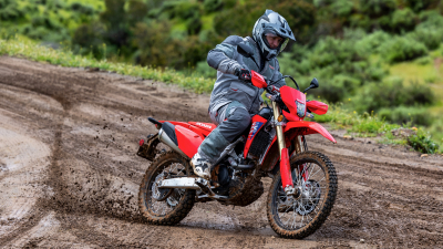 Pilote sur CRF450L descendant une piste en terre.