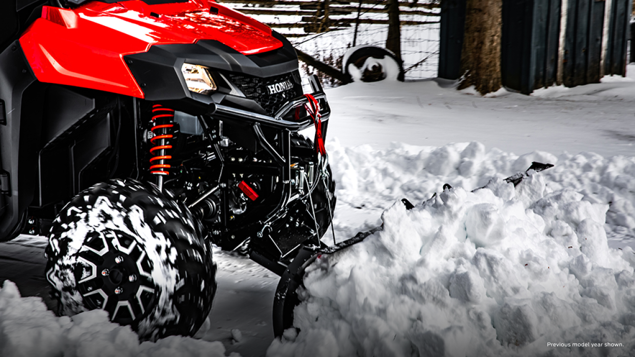 A parked Honda Pioneer 700 with a plow, accessorized model shown