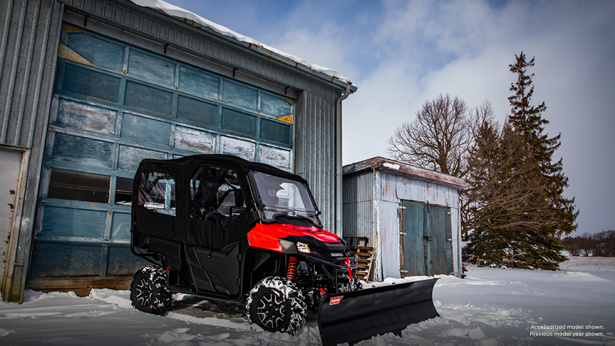 The front end of a Honda Pioneer 700 plowing snow, accessorized model shown