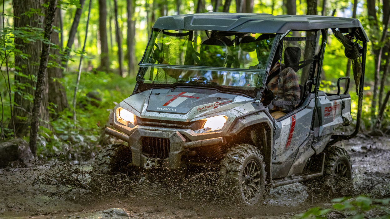 Pioneer front facing, towing trailer through forest.